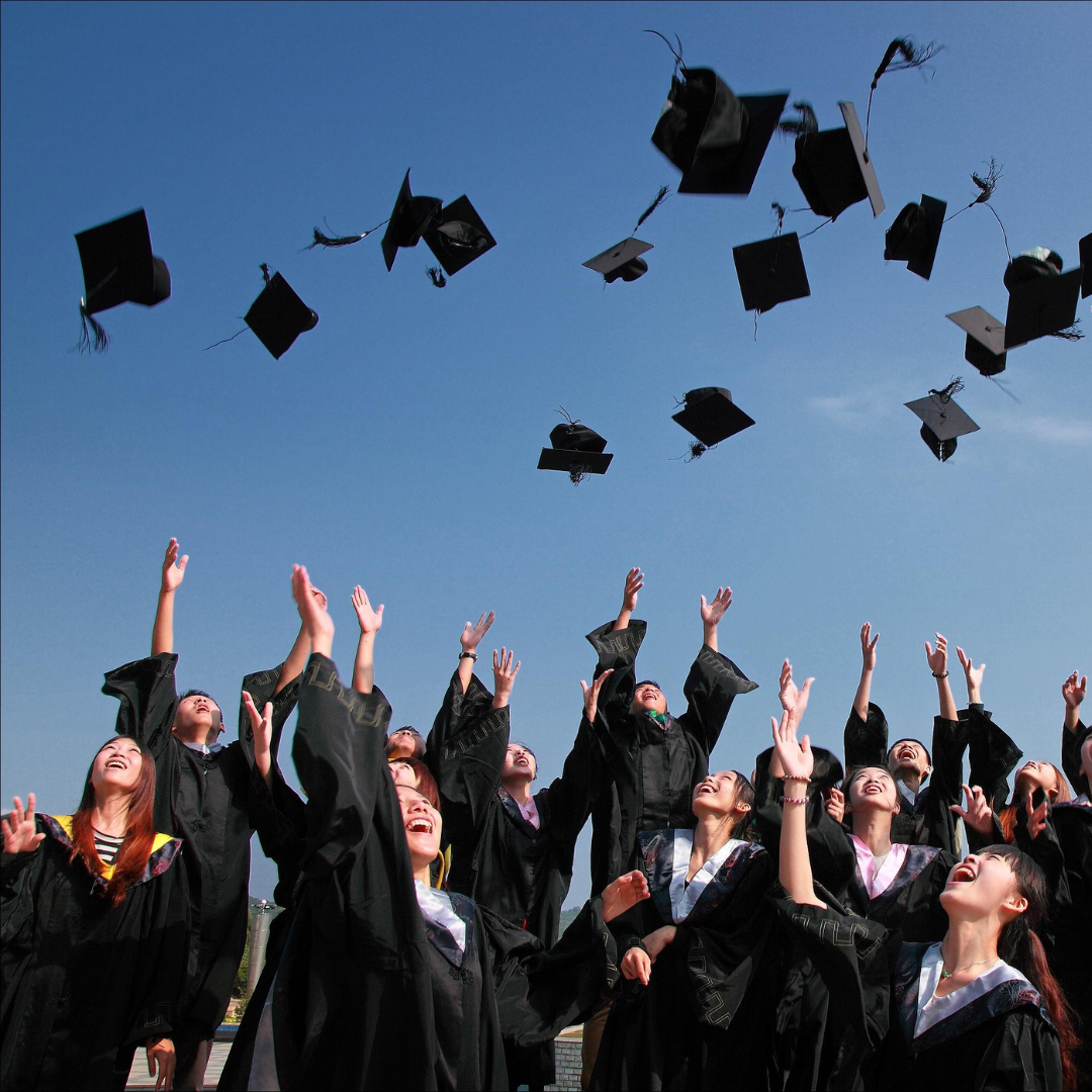 Graduates celebrating by throwing caps in the air